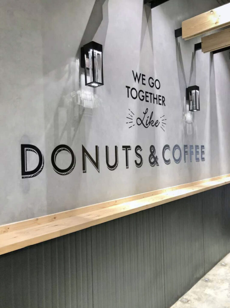 Image of a branding message vertically printed on a concrete wall in a coffee shop